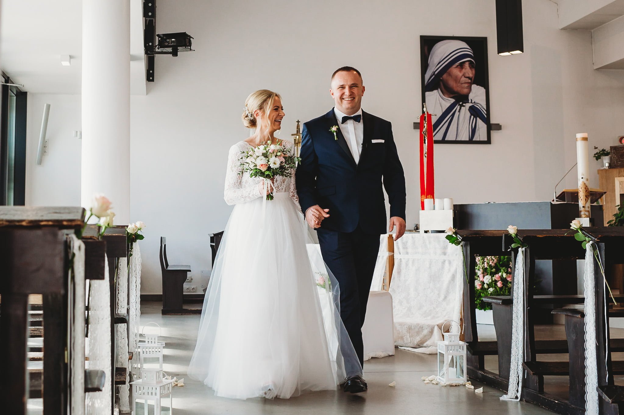 szczęśliwa para młoda z uśmiechem wychodzi z kościoła-fotograf ślubny poznań